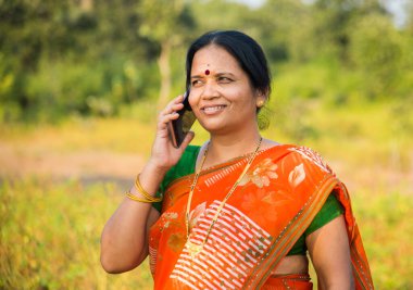 Parkta akıllı telefonu alan bir kadın..