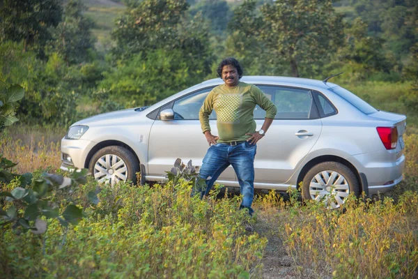 Indian man with his just bought a new car.