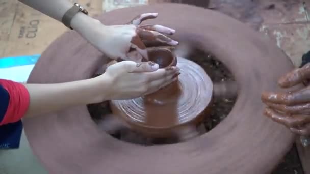 陶芸家の手 陶芸家は彼がセラミックホイールで作業するのを助けるために女性の手に導く — ストック動画