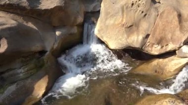 Orman nehri kayalar üzerinde su akıntısı, dağ ormanı nehir kayaları manzarası. 