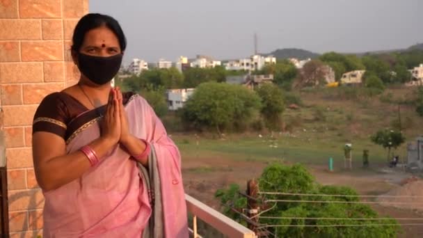 女性はバルコニーを通って通りを見つめているコロナウイルスのパンデミックの間安全のために家にいるインドの女性Covid 19パンデミック — ストック動画