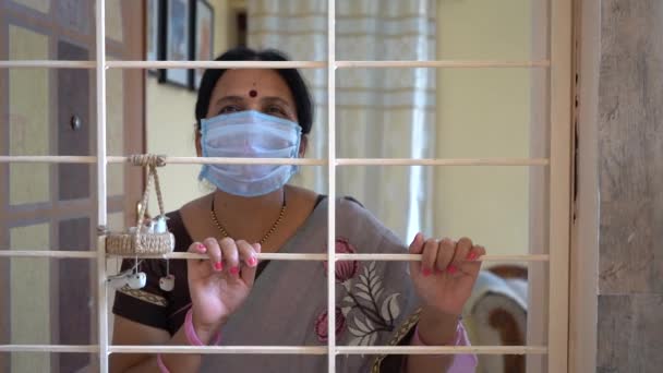 Uma Mulher Quarentena Usar Uma Máscara Olhar Pela Janela Pandemia — Vídeo de Stock