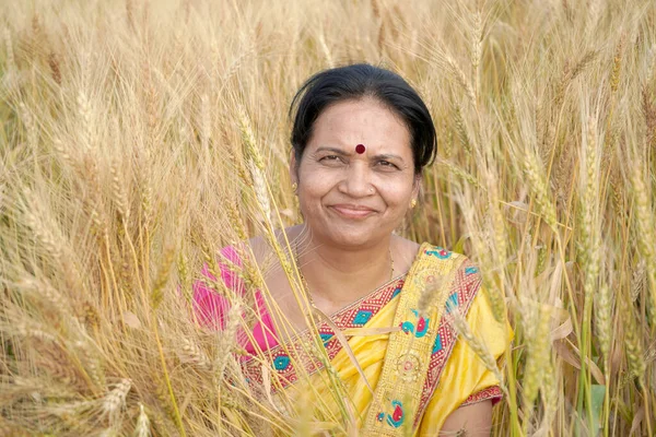 Beautiful young Indian woman wear in saree at the wheat field