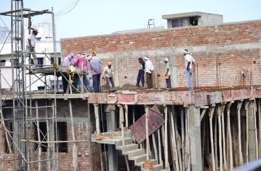 AMRAVATI, MAHARASHTRA, INDIA 9 JUNE 2020 : Construction workers working on a building development site.
