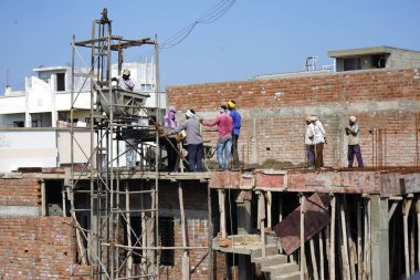 AMRAVATI, MAHARASHTRA, INDIA 9 JUNE 2020 : Construction workers working on a building development site.
