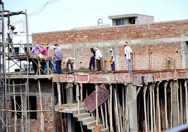 AMRAVATI, MAHARASHTRA, INDIA 9 JUNE 2020 : Construction workers working on a building development site.
