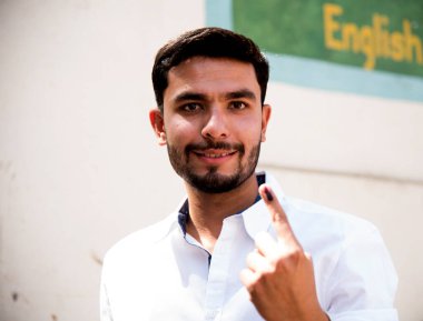 MUMBAI, MAHARASHTRA, INDIA 21 Şubat 2017: İnsanlar, bölgedeki sandık merkezinin önünde oy kullandıktan sonra mürekkep izli parmaklarını gösteriyor.