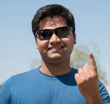 MUMBAI, MAHARASHTRA, INDIA 21 Şubat 2017: İnsanlar, bölgedeki sandık merkezinin önünde oy kullandıktan sonra mürekkep izli parmaklarını gösteriyor.