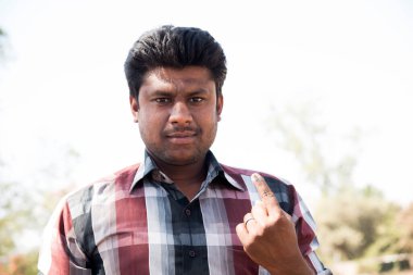 MUMBAI, MAHARASHTRA, INDIA 21 Şubat 2017: İnsanlar, bölgedeki sandık merkezinin önünde oy kullandıktan sonra mürekkep izli parmaklarını gösteriyor.