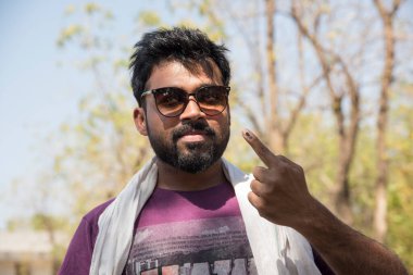 MUMBAI, MAHARASHTRA, INDIA 21 Şubat 2017: İnsanlar, bölgedeki sandık merkezinin önünde oy kullandıktan sonra mürekkep izli parmaklarını gösteriyor.