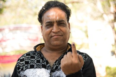 MUMBAI, MAHARASHTRA, INDIA 21 Şubat 2017: İnsanlar, bölgedeki sandık merkezinin önünde oy kullandıktan sonra mürekkep izli parmaklarını gösteriyor.