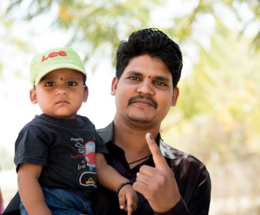 MUMBAI, MAHARASHTRA, INDIA 21 Şubat 2017: Tanımlanamayan kişiler, bölgedeki sandık merkezinin önünde oy kullandıktan sonra mürekkep lekeli parmaklarını gösteriyor.