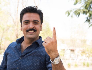 MUMBAI, MAHARASHTRA, INDIA 21 Şubat 2017: Tanımlanamayan kişiler, bölgedeki sandık merkezinin önünde oy kullandıktan sonra mürekkep lekeli parmaklarını gösteriyor.