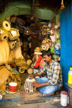 NAGPUR, MAHARASHTRA, INDIA 11 Eylül 2018: Sokak dükkanında müzik aleti ve diğer mallar satan tanımlanamayan sokak satıcısı.