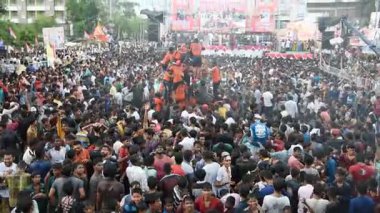 AMRAVATI, MAHARASHTRA, INDIA - 15 AĞUSTOS 2017: Insan kulesi inşa eden ve Tanrı Krishna 'nın doğumunu kutlamak için Dahi Handi festivalinin tadını çıkaran genç insanlar kalabalığı, Hindistan' ın Maharashtra kentinde.
