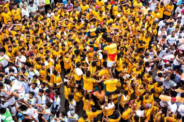MUMBAI, MAHARASHTRA, INDIA 3 Eylül 2018: İnsan kulesi inşa eden ve Tanrı Krishna 'nın Mumbai caddesinde doğumunu kutlamak için Dahi Handi festivalinin tadını çıkaran bir grup genç insan.