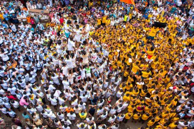 MUMBAI, MAHARASHTRA, INDIA 3 Eylül 2018: İnsan kulesi inşa eden ve Tanrı Krishna 'nın Mumbai caddesinde doğumunu kutlamak için Dahi Handi festivalinin tadını çıkaran bir grup genç insan.