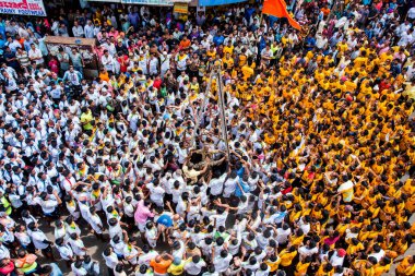 MUMBAI, MAHARASHTRA, INDIA 3 Eylül 2018: İnsan kulesi inşa eden ve Tanrı Krishna 'nın Mumbai caddesinde doğumunu kutlamak için Dahi Handi festivalinin tadını çıkaran bir grup genç insan.