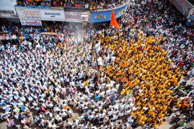 MUMBAI, MAHARASHTRA, INDIA 3 Eylül 2018: İnsan kulesi inşa eden ve Tanrı Krishna 'nın Mumbai caddesinde doğumunu kutlamak için Dahi Handi festivalinin tadını çıkaran bir grup genç insan.