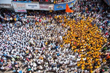 MUMBAI, MAHARASHTRA, INDIA 3 Eylül 2018: İnsan kulesi inşa eden ve Tanrı Krishna 'nın Mumbai caddesinde doğumunu kutlamak için Dahi Handi festivalinin tadını çıkaran bir grup genç insan.