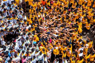 MUMBAI, MAHARASHTRA, INDIA 3 Eylül 2018: İnsan kulesi inşa eden ve Tanrı Krishna 'nın Mumbai caddesinde doğumunu kutlamak için Dahi Handi festivalinin tadını çıkaran bir grup genç insan.