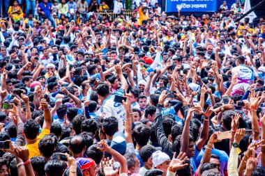 MUMBAI, MAHARASHTRA, INDIA 3 Eylül 2018: İnsan kulesi inşa eden ve Tanrı Krishna 'nın Mumbai caddesinde doğumunu kutlamak için Dahi Handi Festivali' nin tadını çıkaran genç kalabalık.