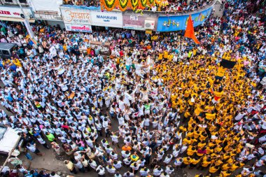 MUMBAI, MAHARASHTRA, INDIA 3 Eylül 2018: İnsan kulesi inşa eden ve Tanrı Krishna 'nın Mumbai caddesinde doğumunu kutlamak için Dahi Handi Festivali' nin tadını çıkaran genç kalabalık.
