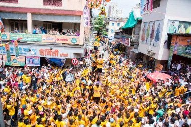 MUMBAI, MAHARASHTRA, INDIA 3 Eylül 2018: İnsan kulesi inşa eden ve Tanrı Krishna 'nın Mumbai caddesinde doğumunu kutlamak için Dahi Handi Festivali' nin tadını çıkaran genç kalabalık.