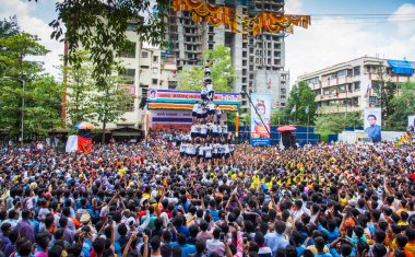 MUMBAI, MAHARASHTRA, INDIA 3 Eylül 2018: İnsan kulesi inşa eden ve Tanrı Krishna 'nın Mumbai caddesinde doğumunu kutlamak için Dahi Handi Festivali' nin tadını çıkaran genç kalabalık.