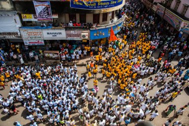 MUMBAI, MAHARASHTRA, INDIA 3 Eylül 2018: İnsan kulesi inşa eden ve Tanrı Krishna 'nın Mumbai caddesinde doğumunu kutlamak için Dahi Handi Festivali' nin tadını çıkaran genç kalabalık.
