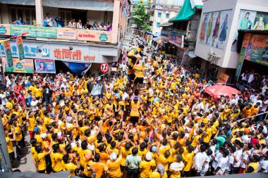 MUMBAI, MAHARASHTRA, INDIA 3 Eylül 2018: İnsan kulesi inşa eden ve Tanrı Krishna 'nın Mumbai caddesinde doğumunu kutlamak için Dahi Handi Festivali' nin tadını çıkaran genç kalabalık.