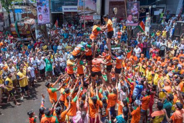 MUMBAI, MAHARASHTRA, INDIA 3 Eylül 2018: İnsan kulesi inşa eden ve Tanrı Krishna 'nın Mumbai caddesinde doğumunu kutlamak için Dahi Handi festivalinin tadını çıkaran bir grup genç insan.