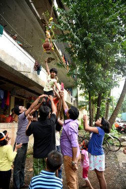 MUMBAI, MAHARASHTRA, INDIA 3 Eylül 2018: İnsan kulesi inşa eden ve Tanrı Krishna 'nın Mumbai caddesinde doğumunu kutlamak için Dahi Handi festivalinin tadını çıkaran bir grup genç insan.