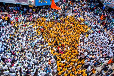 MUMBAI, MAHARASHTRA, INDIA 3 Eylül 2018: İnsan kulesi inşa eden ve Tanrı Krishna 'nın Mumbai caddesinde doğumunu kutlamak için Dahi Handi festivalinin tadını çıkaran bir grup genç insan.