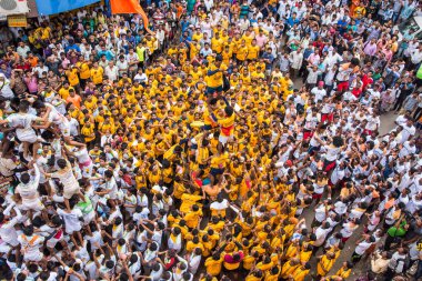 MUMBAI, MAHARASHTRA, INDIA 3 Eylül 2018: İnsan kulesi inşa eden ve Tanrı Krishna 'nın Mumbai caddesinde doğumunu kutlamak için Dahi Handi festivalinin tadını çıkaran bir grup genç insan.