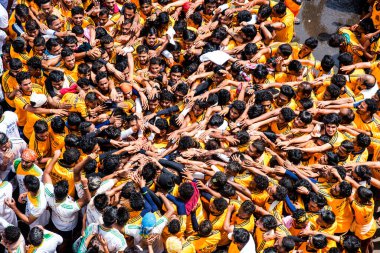 MUMBAI, MAHARASHTRA, INDIA 3 Eylül 2018: İnsan kulesi inşa eden ve Tanrı Krishna 'nın Mumbai caddesinde doğumunu kutlamak için Dahi Handi festivalinin tadını çıkaran bir grup genç insan.