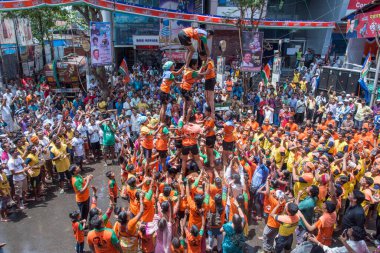 MUMBAI, MAHARASHTRA, INDIA 3 Eylül 2018: İnsan kulesi inşa eden ve Tanrı Krishna 'nın Mumbai caddesinde doğumunu kutlamak için Dahi Handi festivalinin tadını çıkaran bir grup genç insan.