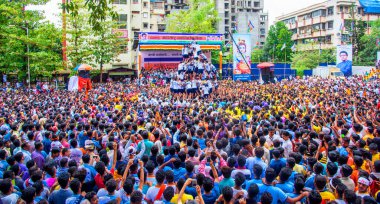 MUMBAI, MAHARASHTRA, INDIA 3 Eylül 2018: İnsan kulesi inşa eden ve Tanrı Krishna 'nın Mumbai caddesinde doğumunu kutlamak için Dahi Handi festivalinin tadını çıkaran bir grup genç insan.