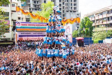 MUMBAI, MAHARASHTRA, INDIA 3 Eylül 2018: İnsan kulesi inşa eden ve Tanrı Krishna 'nın Mumbai caddesinde doğumunu kutlamak için Dahi Handi festivalinin tadını çıkaran bir grup genç insan.