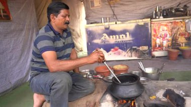 NAGPUR, MAHARASHTRA, INDIA, 25 Ocak 2023: Kadınlar, eski mutfağın kırsal kesimlerinde odun kullanarak taze yemek pişiriyor ve pişiriyor.