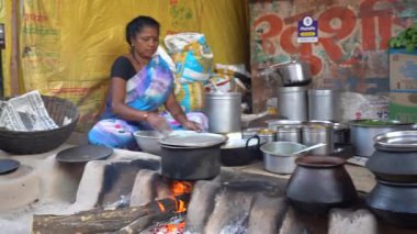 NAGPUR, MAHARASHTRA, INDIA, 25 Ocak 2023: Kadınlar, eski mutfağın kırsal kesimlerinde odun kullanarak taze yemek pişiriyor ve pişiriyor.