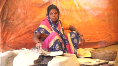 NAGPUR, MAHARASHTRA, INDIA, 25 Ocak 2023: Kadınlar, eski mutfağın kırsal kesimlerinde odun kullanarak taze yemek pişiriyor ve pişiriyor.