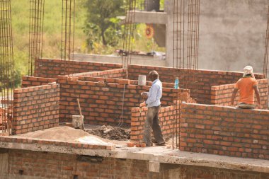 MUMBAI, MAHARASHTRA, INDIA 12 Kasım 2019: İnşaat işçileri bir inşaat sahasında çalışıyor. Hindistan 'da inşaat işçileri iş yerinde güvenlik önlemi almıyorlar..