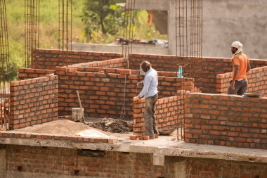 MUMBAI, MAHARASHTRA, INDIA 12 Kasım 2019: İnşaat işçileri bir inşaat sahasında çalışıyor. Hindistan 'da inşaat işçileri iş yerinde güvenlik önlemi almıyorlar..