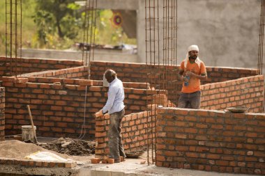 MUMBAI, MAHARASHTRA, INDIA 12 Kasım 2019: İnşaat işçileri bir inşaat sahasında çalışıyor. Hindistan 'da inşaat işçileri iş yerinde güvenlik önlemi almıyorlar..