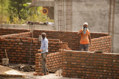 MUMBAI, MAHARASHTRA, INDIA 12 Kasım 2019: İnşaat işçileri bir inşaat sahasında çalışıyor. Hindistan 'da inşaat işçileri iş yerinde güvenlik önlemi almıyorlar..