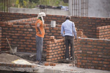 MUMBAI, MAHARASHTRA, INDIA 12 Kasım 2019: İnşaat işçileri bir inşaat sahasında çalışıyor. Hindistan 'da inşaat işçileri iş yerinde güvenlik önlemi almıyorlar..