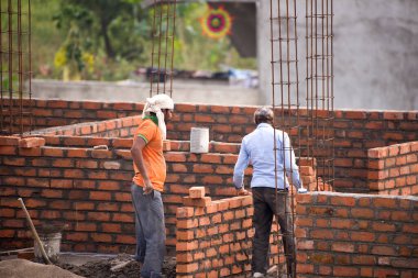MUMBAI, MAHARASHTRA, INDIA 12 Kasım 2019: İnşaat işçileri bir inşaat sahasında çalışıyor. Hindistan 'da inşaat işçileri iş yerinde güvenlik önlemi almıyorlar..