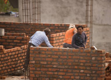 MUMBAI, MAHARASHTRA, INDIA 12 Kasım 2019: İnşaat işçileri bir inşaat sahasında çalışıyor. Hindistan 'da inşaat işçileri iş yerinde güvenlik önlemi almıyorlar..