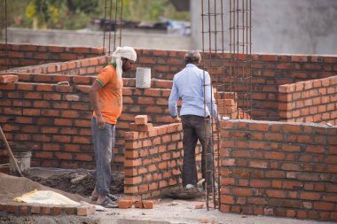 MUMBAI, MAHARASHTRA, INDIA 12 Kasım 2019: İnşaat işçileri bir inşaat sahasında çalışıyor. Hindistan 'da inşaat işçileri iş yerinde güvenlik önlemi almıyorlar..